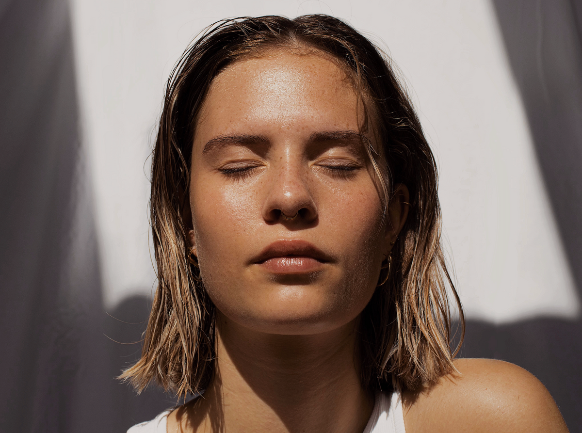 Woman with clear skin and her eyes closed.